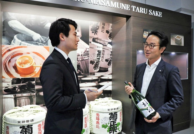 嘉納治郎右衛門社長（右）に話を聞く関西学院大３年の黒澤良輔さん＝神戸市東灘区魚崎西町１、樽酒マイスターファクトリー