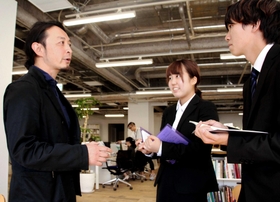 岡崎忠彦社長（左）に話を聞く関西学院大３年の畑中初音さん（中央）と北川英太郎さん＝神戸市中央区磯上通４