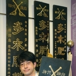 資料展示室で看板を持つ多木勝彦・取締役上席常務執行役員。神代鍬の印に「創業者の精神が感じられる」＝加古川市別府町緑町