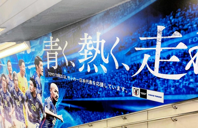 サッカー日本代表を応援するＴＯＹＯＴＩＲＥがＪＲ渋谷駅構内に掲示している広告（同社提供）