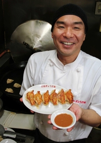 焼きギョーザを手にする頃末灯留さん。「みそだれだけがお勧めですが、しょうゆや酢で割っても味に奥行きが出ます」＝神戸市中央区栄町通２