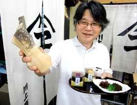 山椒の花や木の皮を使った佃煮と、山椒の木を持つ川上良さん＝神戸市北区有馬町、川上商店