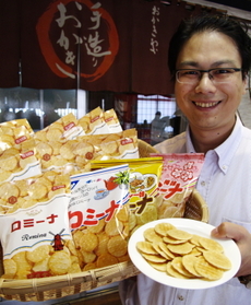ロミーナを持つ岩本社長。発売当初のパッケージを復刻販売した。「レトロでかわいいと女性に人気です」＝豊岡市中陰
