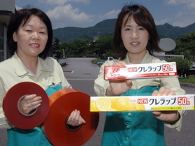 クレハ樹脂加工事業所でつくるクレラップ。左は、チーズの包装フィルムをはがす際に引っ張る赤い「カットテープ」。これも製造する＝丹波市柏原町北中