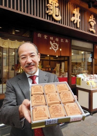 店頭で商品を手にする松井佐一郎社長。「焼き印で細かい絵柄を出せるのも老舗ならではです」＝神戸市中央区元町通６