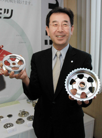 光り輝くプーリを手にする金光俊明社長。創業の地に根を張り、世界に製品を届ける＝明石市大蔵本町、カネミツ
