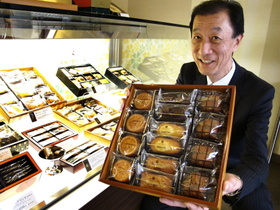 有名パティシエが開発した「神戸ガトー倶楽部」を持つ執行役員の山本憲司さん＝尼崎市尾浜町１、エーデルワイス本部センター
