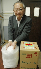 天然ハッカの結晶を手にする和田芳明社長。箱には鈴木商店の屋号「カネタツ」の印が光る＝神戸市灘区下河原通１、鈴木薄荷本社