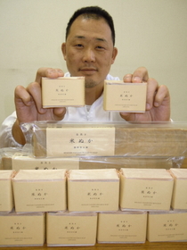 米ぬか石鹸を手に取る西垣壮南代表＝三木市別所町下石野、丸菱油脂石鹸化学工業所
