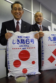 肥料を持つ野上さん（左）と衣笠さん。「今もうちの肥料のトップランナー」と口をそろえる＝加古川市別府町新野辺、多木化学