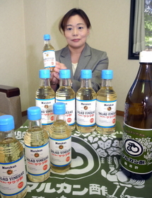 ハイカラ感漂うラベルの「サラダ酢」をＰＲする林さん。常温で日持ちする点も主婦に受けているという＝神戸市東灘区向洋町西５、マルカン酢 