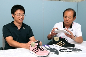 靴を前に話し込む三村修司さん（左）と父仁司さん＝高砂市米田町古新、ミムラボ（撮影・辰巳直之）