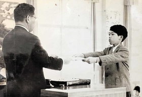 神戸市立西須磨小の卒業式で、卒業証書を受け取る橋本康彦さん（右）。このころからロボットが大好きだった＝１９７０年（本人提供）