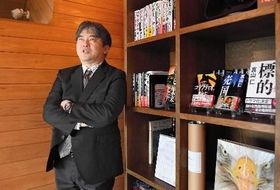 著作が並ぶ書棚の前で就職活動のころを振り返る真山仁さん＝東京都文京区（撮影・棚橋慶太）