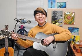 ギターを手に会社員からミュージシャンになったいきさつを話す土居康宏さん＝神戸市中央区（撮影・後藤亮平）