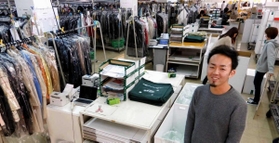 クリーニングを終えた衣類を梱包、発送する出荷センターに立つ東田伸哉社長＝西脇市下戸田