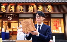 今では数社しか作れない特大瓦せんべいを手にする５代目店主、松井隆昌さん＝神戸市中央区元町通６、亀井堂総本店