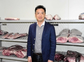 さまざまな部位の肉が並ぶ冷蔵庫に立つ井上直哉社長＝神戸市須磨区常盤町２、グローイングコンセプション