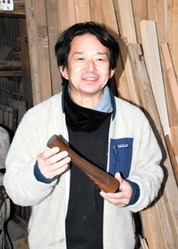 シェアウッズの山崎正夫社長。手にするのは神戸ポートタワーをモチーフにした木製トロフィー。神戸市都市デザイン賞の受賞者に贈られた＝神戸市兵庫区西出町１