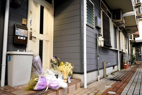 現場となった民家。玄関には花が供えられていた＝１０日午後、宝塚市安倉西２