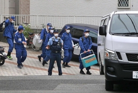 現場検証を終え、荷物を持って引き上げる捜査員ら＝５日午後、宝塚市安倉西２