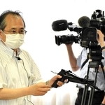 条例案の有識者検討会で実物のボーガンを手に説明する県の担当者＝７月、神戸市中央区