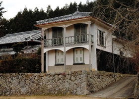 石垣の上に建つ秋景楼。内部の見学はできないが、田畑越しに見える姿の撮影やスケッチに訪れる人は多い＝三田市川原