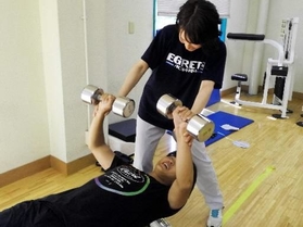 トレーニング室で常勤トレーナーから指導を受ける学生＝神戸市東灘区、甲南大