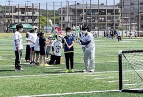 学生からラクロスを教わる子どもたち