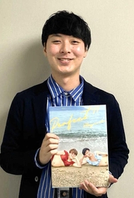 番組内で作成したビキニの写真集を持つ神吉将也さん（本人提供）