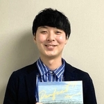 番組内で作成したビキニの写真集を持つ神吉将也さん（本人提供）