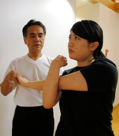 前屈や背伸びなど、基本的な体の屈伸で、その人の柔軟性、ゆがみなどを確認する＝芦屋市内