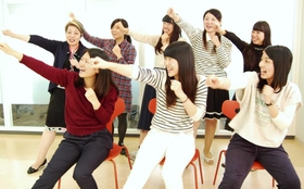 往年のヒット曲「瀬戸の花嫁」に乗せた体操を披露する学生ら。高齢者と楽しんでいる＝西宮市武庫川町、武庫川女子大