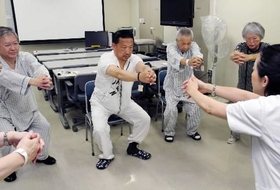 理学療法士の指導で、太ももの筋肉を鍛える糖尿病の入院患者ら＝神戸大学病院