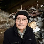 使い古された金属が集まる工場に立つ榎忠さん。数々の作品の着想を得てきた＝神戸市長田区東尻池町１、兼正興業（撮影・秋山亮太）