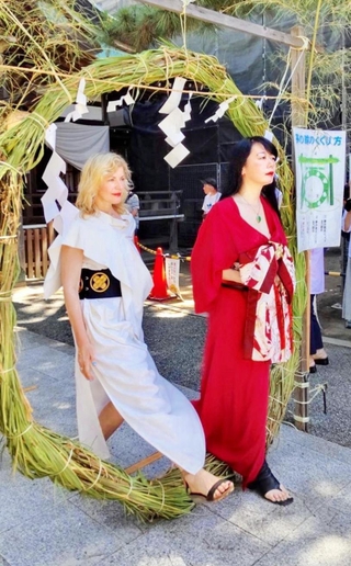 おしゃたか舟神事が行われた岩屋神社で茅の輪をくぐるテルミン奏者のドリット・クライスラーさん（左）とピアニストの牧村英里子さん＝明石市材木町