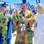 おしゃたか舟神事を見学し、茅の輪を手にする氏子らと話すテルミン奏者のドリット・クライスラーさん（右）＝明石市港町