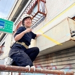 緑の看板のそばで制作する山田悠さん＝神戸市中央区元町高架通２