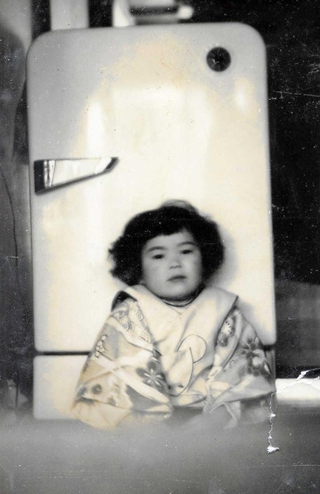 自宅の冷蔵庫の前に座る幼少期の上沼恵美子さん