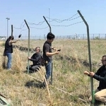 神戸空港島で撮影用のフェンスを作るスタッフ（神戸フィルムオフィス提供）
