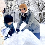 たくさんの雪が積もる公園で、息子と娘とかまくら作り