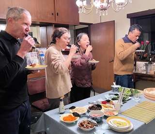 自分で巻いた恵方巻きを食べる外国人アーティストたち。右から２人目が筆者＝神戸市中央区北野町４
