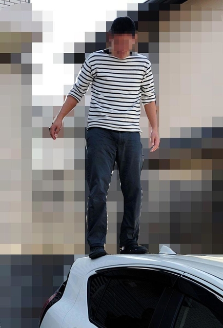 男性教員が所有する車の上に乗る加害側の教員（提供写真、画像の一部を加工しています）