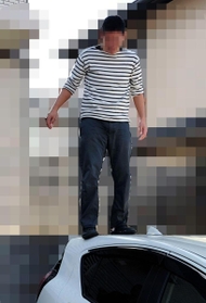 男性教員が所有する車の上に乗る加害側の教員（提供写真、画像の一部を加工しています）