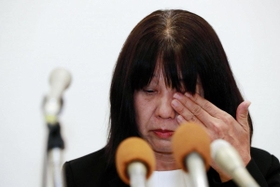 教諭間の暴行・暴言問題についての会見中、涙をぬぐう神戸市立東須磨小学校の校長（右）ら＝９日午後、神戸市役所（撮影・斎藤雅志）