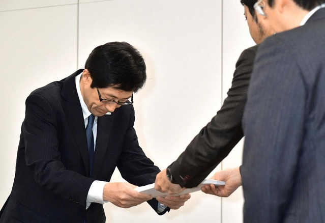 調査委員会の報告書を受け取る長田淳教育長（左）＝２１日午後、神戸市中央区東川崎町１、市教育委員会事務局（撮影・秋山亮太）