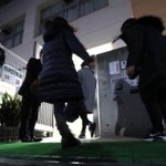 説明会に参加するため、東須磨小学校に入る保護者ら＝２８日午後、神戸市須磨区堀池町１（撮影・辰巳直之）