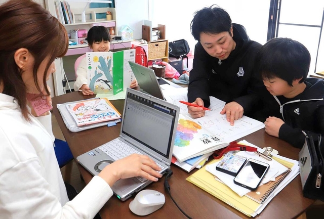 在宅で仕事しながら、子どもの面倒を見る一家＝神戸市西区（撮影・大森　武）