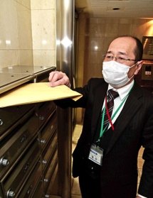 生徒宅に課題などが入った封筒を届ける教員＝神戸市中央区（撮影・後藤亮平）