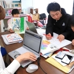 在宅で仕事しながら、子どもの面倒を見る一家＝神戸市西区（撮影・大森　武）
